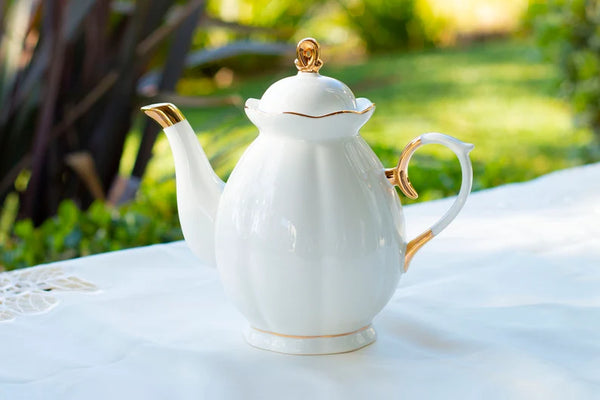 white tea pot with gold trim